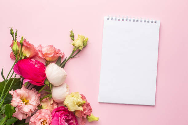istock Notebook and pink flower bouquet on pastel background 1282262243