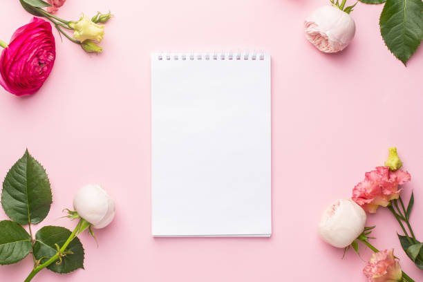 istock Notebook and pink flower bouquet on pink background 1282262327