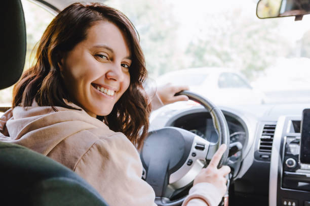 giovane bella donna autista seduto in auto - car insurance women driving foto e immagini stock