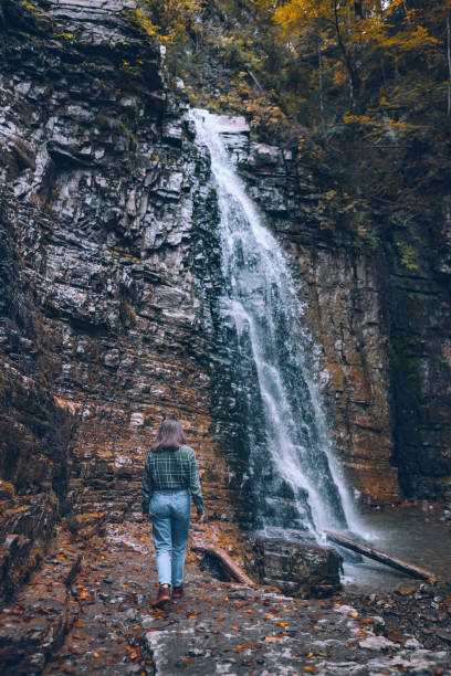 istock woman in casual clothes looking at waterfall 1282263179