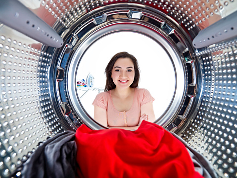looking from inside a washing machine to a happy housewife