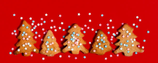 istock Gingerbread christmas trees cookie decorated with mastic star icing on bright red background. Festive, holiday cooking concept. 1282263978