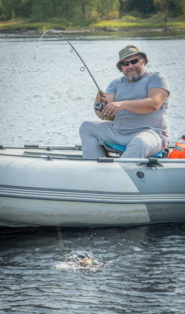 istock A man in a boat on a large river fishing. 1282264503