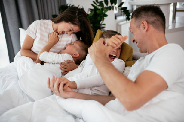 istock Happy parents with sons relaxing in bed 1282264830
