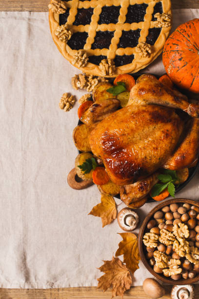 istock Fall thanksgiving table with roasting chicken or turkey, nuts, pie, pumkins and other food on light tablecloth 1282265229