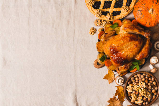 istock Fall thanksgiving table with roasting chicken or turkey, nuts, pie, pumkins and other food on light tablecloth 1282265231