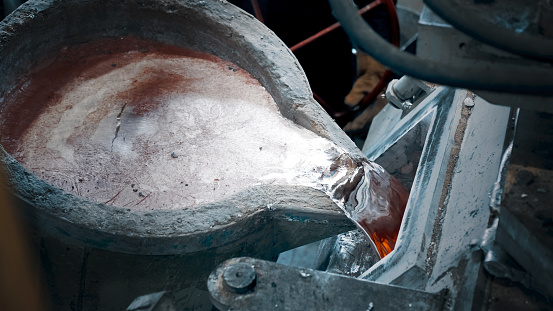 Ladle with molten metal is poured into a mold.