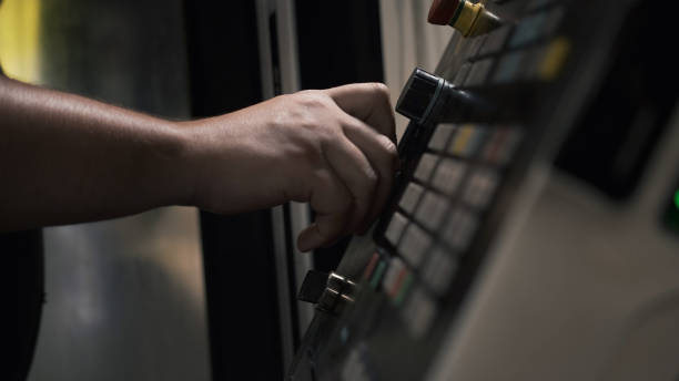 istock Worker pressing buttons on CNC machine control board in factory 1282265368