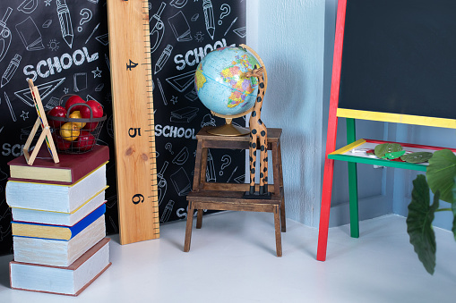 Interior of elementary school. Chalkboard, Books, globe and stationery on classroom. Teachers Day concept. Back to school. Empty classroom with blackboard. Kindergarten. Interior of children's room