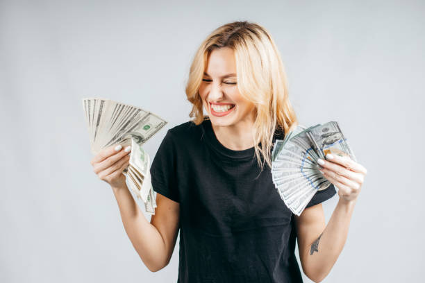 istock Surprised blonde girl  with money 1282270565