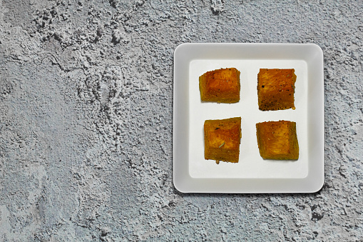 Baked pumpkin in a white plate. Pumpkin cooked in the oven. Cut pieces of pumpkin.A traditional autumn dish of baked pumpkin.