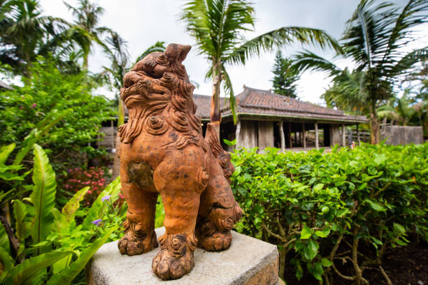 July/23/2019 in Onna village, Okinawa a Shisa guards the front of an old traditional style house.