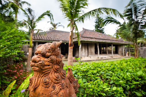 July/23/2019 in Onna village, Okinawa a Shisa guards the front of an old traditional style house.