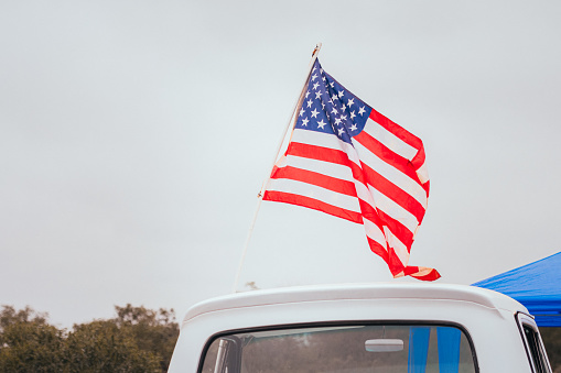 American flag on roof of vintage Ford F100 truck