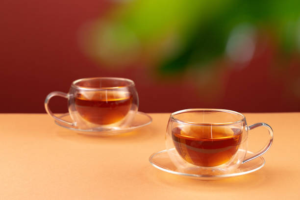 istock Two glass cups of black tea on beige table 1282279280