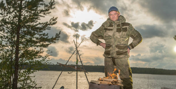 istock A man next to a burning fire in evening sevens. 1282279346