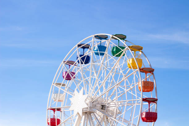 istock Ferris wheel with multi-colored cabs on a background of blue sky 1282279932