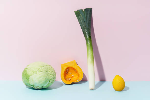Leek, butternut squash, cabbage and lemon on pink background. Vegetarian food ingredients. Healthy dieting concept.