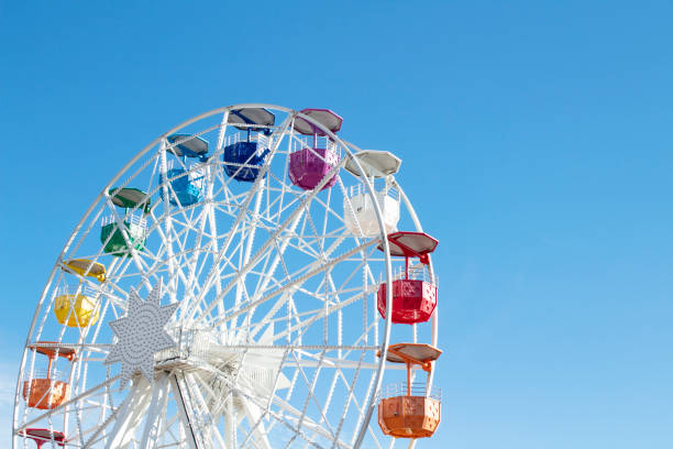 istock Ferris wheel with multi-colored cabs on a background of blue sky 1282280268