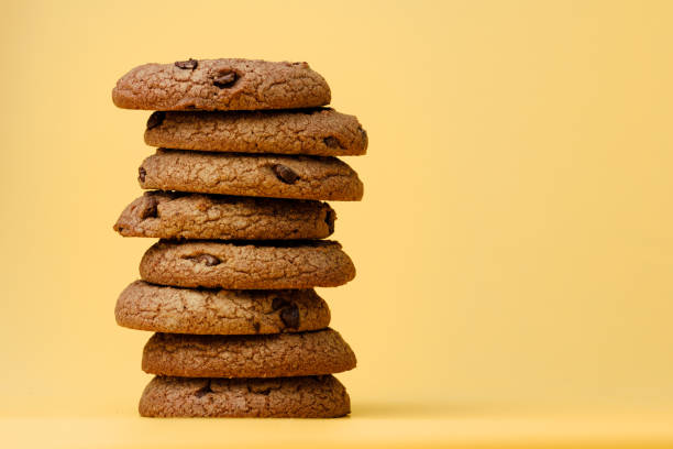 istock Pile of chocolate chip cookies on yellow backgreound 1282280471
