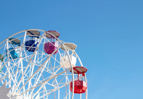 istock Ferris wheel with multi-colored cabs on a background of blue sky 1282280508