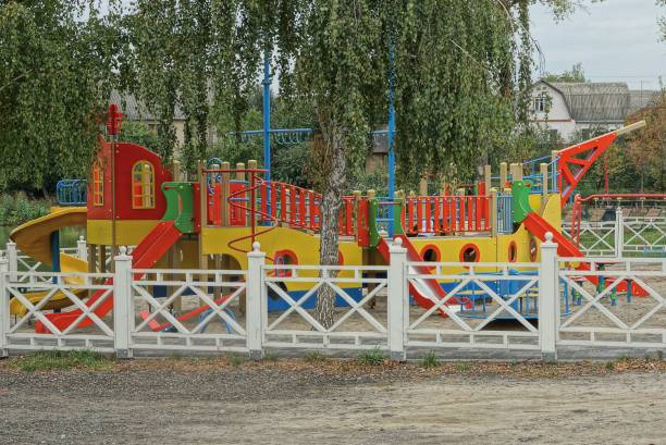 colored structures in among the green branches of a tree on the playground