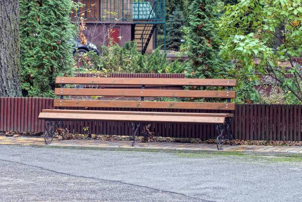 istock one empty brown wooden bench stands on gray asphalt 1282281168