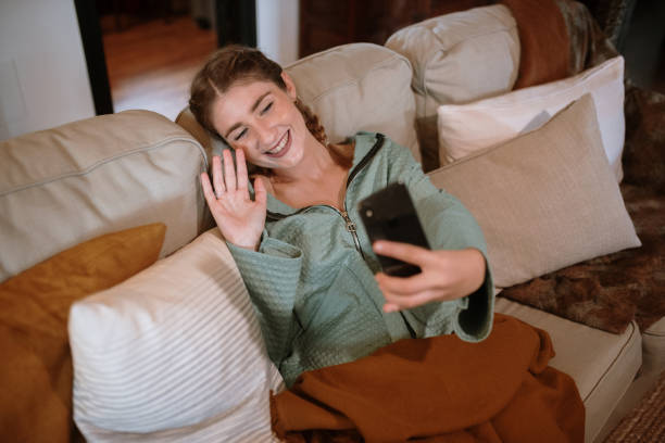 istock Young woman in a video call sitting in a sofa 1282281768