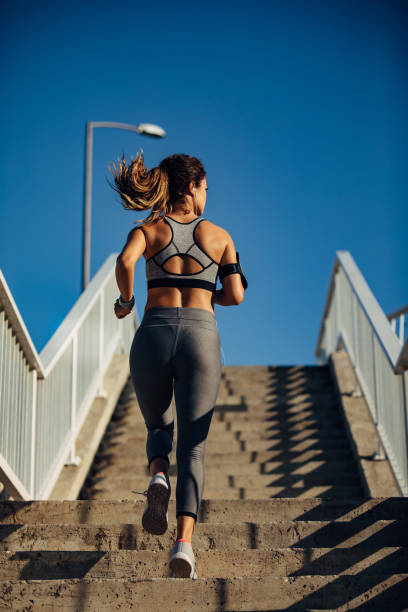istock Young woman jogging up the stairs 1282281856