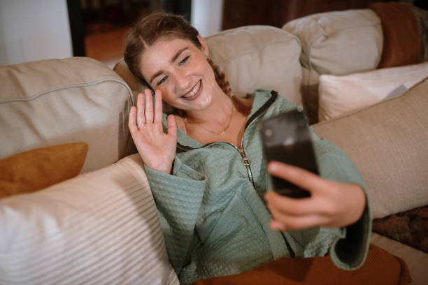 istock Young woman in a video call sitting in a sofa 1282281866