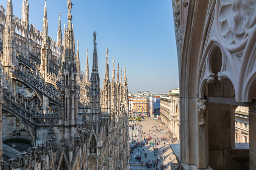 Milan, Italy - Apr 17, 2019: View at statues on roof of Duomo di Milano and Galleria Vittorio Emanuele II at background