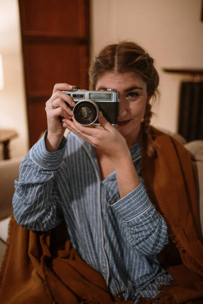 istock Young woman with a vintage camera at home 1282282337