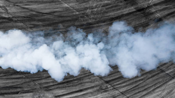 schwarze reifenspuren und weißer rauch auf asphalt-rennstrecke, straßenstaubwolke aus dem fahrenden auto, verbrennungsdämpfe von autoauspuffrohr, der motor funktioniert nicht richtig. - smoke trails stock-fotos und bilder