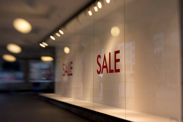 sale written in red letters on the on the pane of an empty shop window