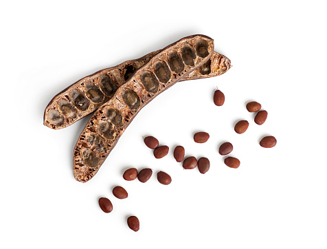 top view carob with scattered seeds isolated on white background