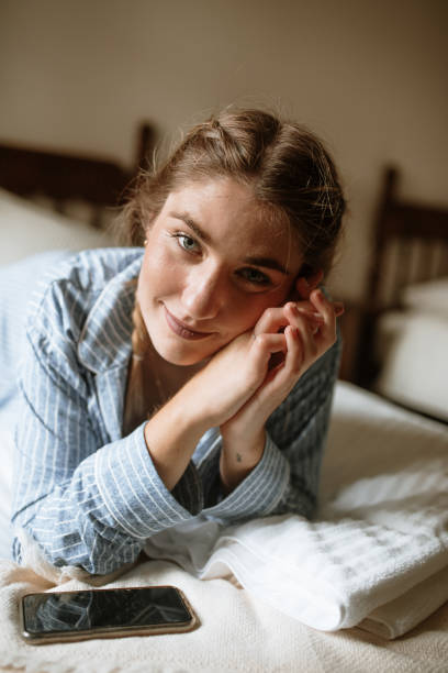 istock Young woman using a smart phone on a bed 1282288704