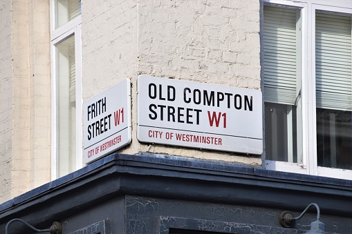 London, United Kingdom - October 25 2020: Detail of Old Compton Street and Frith Street signs in Soho, West End.