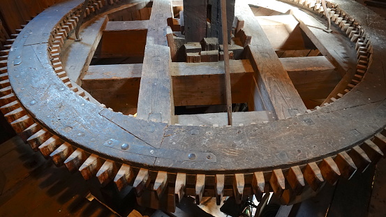 Large, wooden flywheel of a mill used to grind grain into flour - gear, toothed wheel