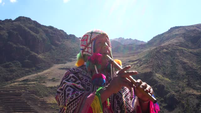 Senior man dressing traditional peruvian clothing and playing flute