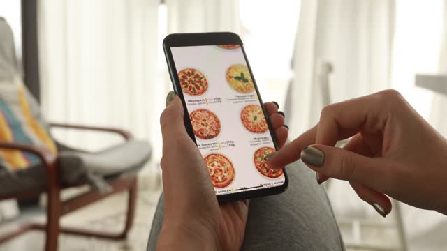 Woman ordering pizza at home online