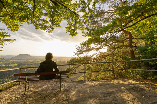 istock Woman enjoying evening view in Elbsandstein Mountains 1282296093