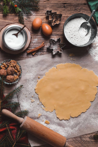 выпечка домашнего рождественского печенья на деревенском деревянном столе - baking paper cookie tray стоковые фото и изображения