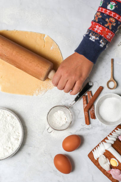 выпечка домашнего рождественского печенья на белом столе - baking paper cookie tray стоковые фото и изображения