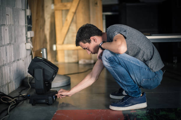 lighting technician electric engineer adjusting focus of lighting elements backstage 9 - ropes backstage theater imagens e fotografias de stock