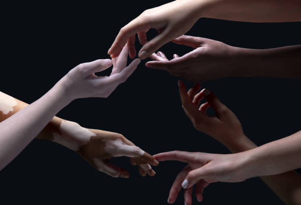Open hearts. Hands of different people in touch isolated on black studio background. Concept of relation, diversity, inclusion, community, togetherness. Weightless touching, creating one unit.