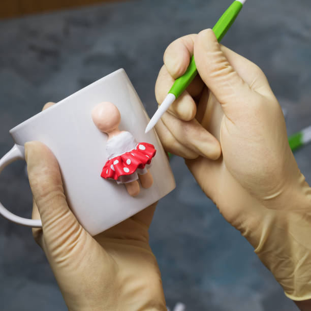 istock The master makes a figurine of a person on a mug from polymer clay 1282302426