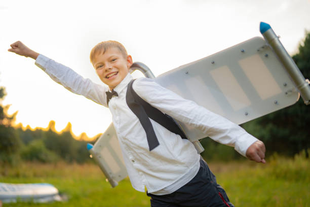 istock Boy in jetpack wings playing on a meadow. Pretending to fly 1282302669
