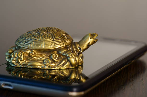 istock Metal turtle on a mobile phone. 1282305519