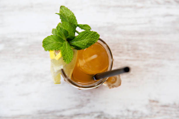 istock Sugarcane juice with lemon viewed from above on wooden background. 1282305528