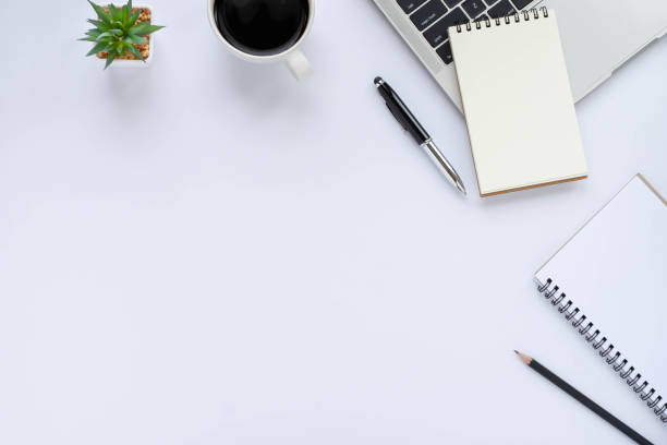 istock Top view above of White office desk table with keyboard, notebook and coffee cup with equipment other office supplies. Business and finance concept. Workplace, Flat lay with blank copy space. 1282305895